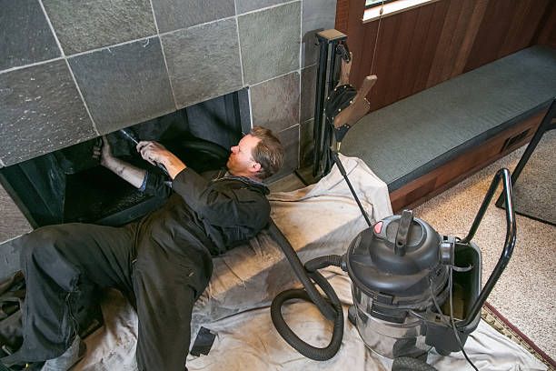 Technician servicing a slate-faced hearth under cloths