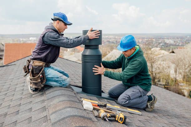 Two technicians seating a steel chimney section on a ridge